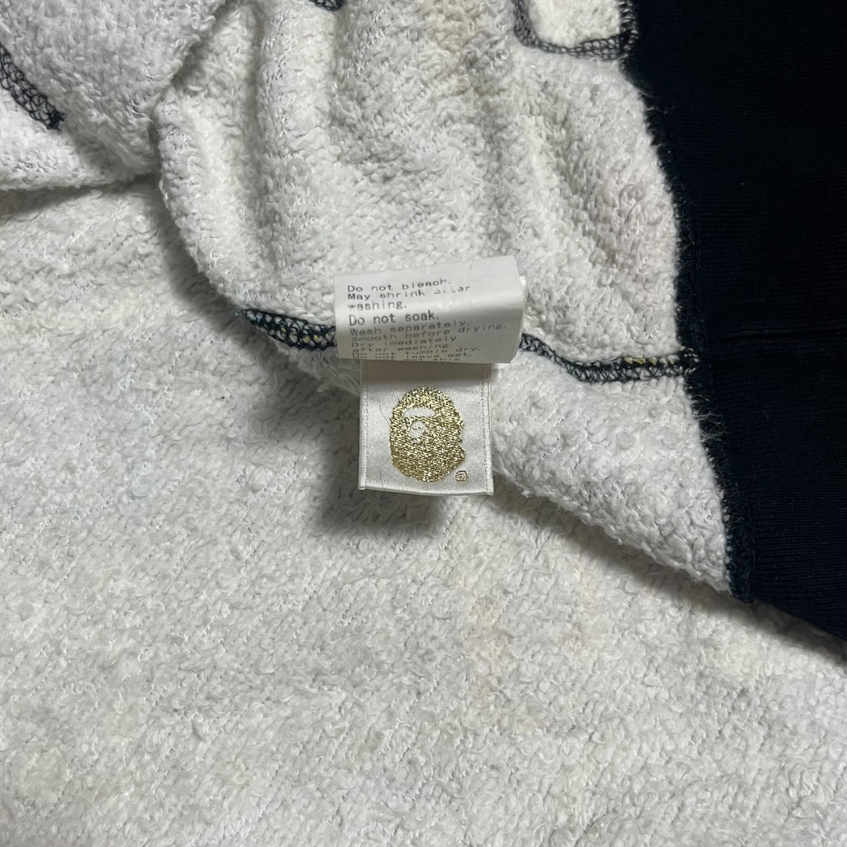 Care label tag of BAPE STA Milo Animal Full Zip Hoodie on a soft fabric background - BAPE X Nigo M.